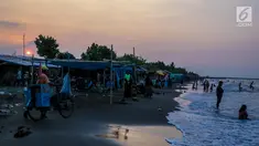 Pengunjung menikmati senja di Pantai Randusanga Indah, Brebes, Jawa Tengah, Minggu (2/7). Pantai Randusanga Indah menjadi salah satu destinasi wisata bagi para pemudik yang melewati jalur Pantura. (Liputan6.com/Faizal Fanani)
