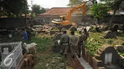 Petugas menggunakan kendaraan alat berat membongkar bangunan liar di kawasan TPU Menteng Pulo, Jakarta Selatan (7/4). Sebanyak 225 bangunan liar semi-permanen dibongkar karena berdiri di atas lahan TPU. (Liputan6.com/Gempur M Surya)