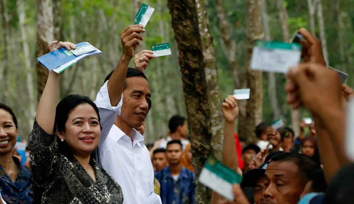 Menko Bidang Pembangunan Manusia dan Kebudayaan, Puan Maharani mendampingi Presiden Joko Widodo membagikan Kartu Indonesia Sehat kepada para pekerja di Kabupaten Deli Serdang, Sumatera Utara, Sabtu (18/4). (Liputan6.com/Pool)