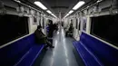 Komuter naik kereta bawah tanah di Beijing, China, Senin (17/2/2020). Tak seperti pada jam-jam sibuk di hari biasa, wabah virus corona atau COVID-19 membuat kereta dan transportasi publik lainnya di Beijing menjadi sepi. (AP Photo/Andy Wong)