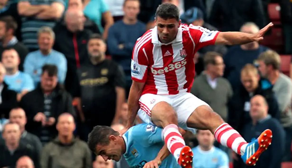 Striker Stoke City Jonathan Walters (atas) duel udara dengan bek Manchester City Aleksandar Kolarov (bawah) pada pertandingan sepak bola Liga Inggris antara Stoke City vs Manchester City di Stadion Britannia. (14/09/13). (AFP/Lindsey Parnaby)