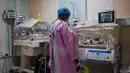 Safina Namukwaya, 70, memeriksa bayi kembarnya di dalam inkubator di Women's Hospital International and Fertility Centre setelah melahirkan di Kampala, Minggu (3/12/2023). (BADRU KATUMBA / AFP)