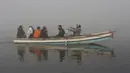 Orang-orang naik perahu di Sungai Ravi saat kabut tebal menyelimuti Lahore, Pakistan, Selasa (30/11/2021). Lahore secara konsisten menempati peringkat sebagai salah satu kota terburuk di dunia untuk polusi udara. (AP Photo/K.M. Chaudary)