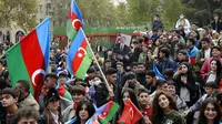 Rakyat Azerbaijan mengibarkan bendera nasional di Baku, Azerbaijan, Selasa (10/11/2020). Armenia dan Azerbaijan mengumumkan perjanjian damai untuk menghentikan pertempuran atas wilayah Nagorno-Karabakh di Azerbaijan berdasarkan pakta yang ditandatangani dengan Rusia. (AP Photo)