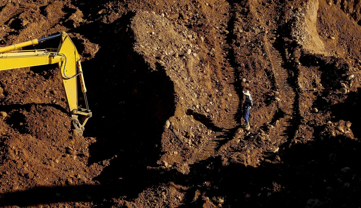 Alat berat digunakan petugas untuk mencari para korban longsor di lokasi tambang Hpakant giok, Myanmar, (21/11). Longsor terjadi disebuah perkemahan kumuh yang berada tepat disebelah pertambangan. (REUTERS/Stringer)