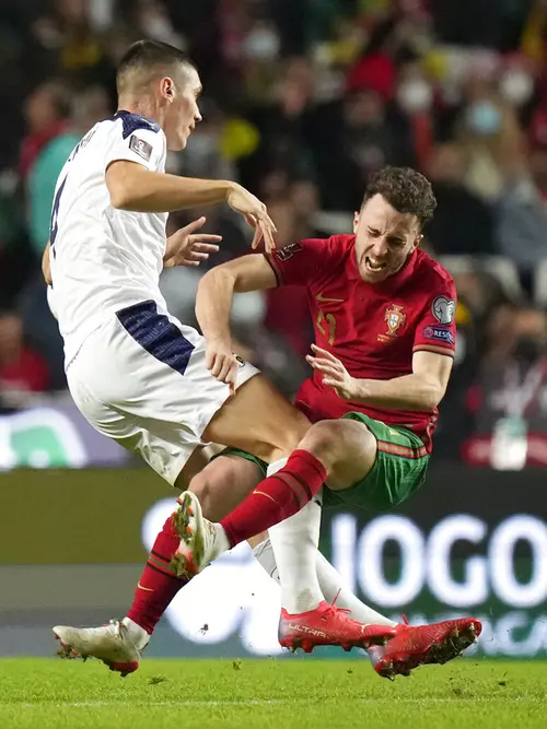 Pemain Serbia Nikola Milenkovic (kiri) melanggar pemain Portugal Diogo Jota pada pertandingan kualifikasi Grup A Piala Dunia 2022 di Stadion Luz, Lisbon, 14 November 2021. Serbia menang 2-1. (AP Photo/Armando Franca)