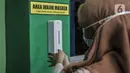 Guru menggunakan hand sanitizer sebelum memasuki kelas saat Simulasi Persiapan Kelas Hybrid dalam Pembelajaran Jarak Jauh di SMPN 255, Jakarta, Selasa (30/3/2021). Kelas Hybrid merupakan model sekolah tatap muka secara rotasi dengan jumlah kehadiran siswa 50 persen. (merdeka.com/Iqbal S Nugroho)