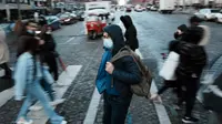 Seorang pria yang mengenakan masker untuk mencegah penyebaran COVID-19, melintasi jalan Champs Elysees, di Paris, Selasa (28/12/2021). Pihak berwenang Senin (27/12) telah memberlakukan pembatasan drastis sebelum Malam Tahun Baru. (AP Photo/Thibault Camus)