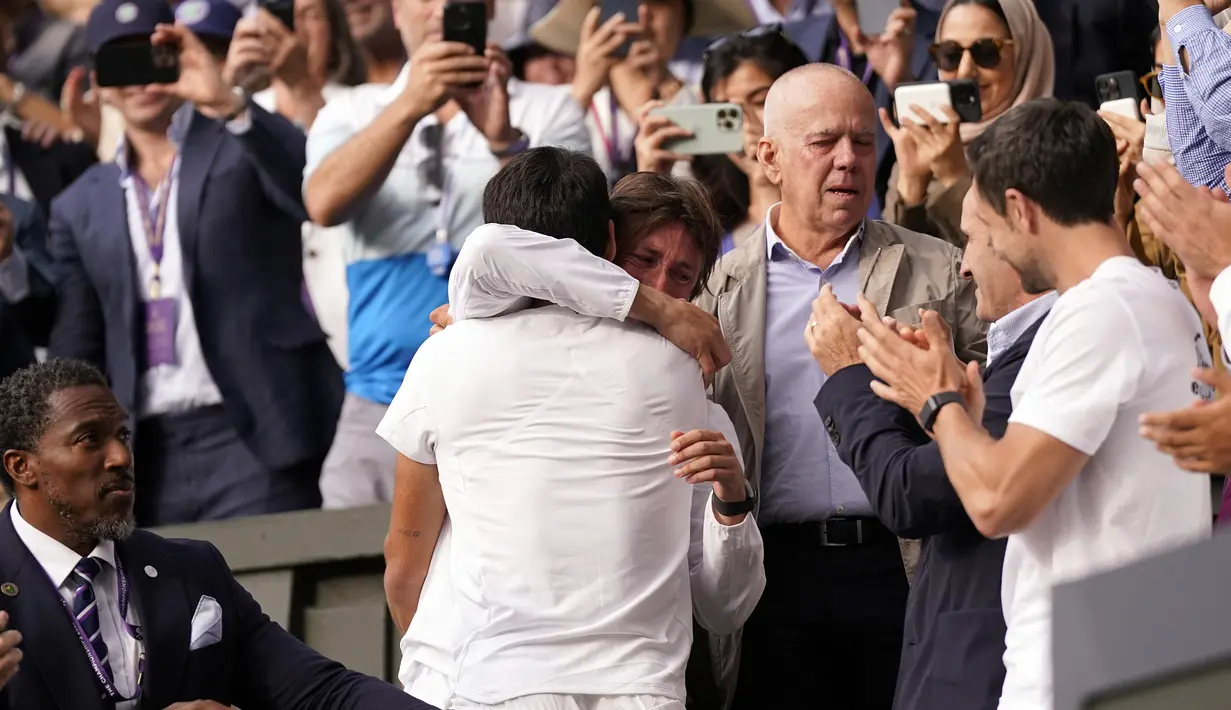 Petenis Spanyol, Carlos Alcaraz merayakan kemenangan bersama rekan dan keluarga setelah mengalahkan petenis Serbia, Novak Djokovic pada laga final tunggal putra turnamen tenis Grand Slam Wimbledon 2023 di All England Lawn and Tennis Club, London, Minggu (16/7/2023) malam WIB. Carlos Alcaraz menang 3-2 (1-6, 7-6 (6), 6-1, 3-6 dan 6-4). (AP Photo/Alberto Pezzali)