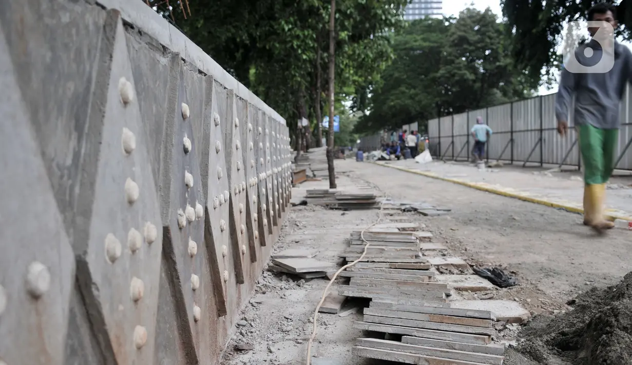 Pekerja Dinas SDA menyelesaikan proyek revitalisasi trotoar di Jalan RM Margono Djojohadikoesoemo, Jakarta, Kamis (16/1/2020). Trotoar di sisi selatan Kanal Banjir Barat itu akan dilengkapi taman dan deck view untuk melihat pemandangan Kali Ciliwung dan gedung perkantoran (merdeka.com/Iqbal Nugroho)