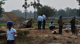 Tentara Myanmar menjaga reruntuhan jet tempur yang jatuh di area persawahan desa Kyunkone, berjarak satu jam dari ibu kota Naypyidaw, Selasa (3/4). Kantor kepala militer menyebut kecelakaan pesawat tempur itu dikarenakan kesalahan teknis. (AFP Photo)