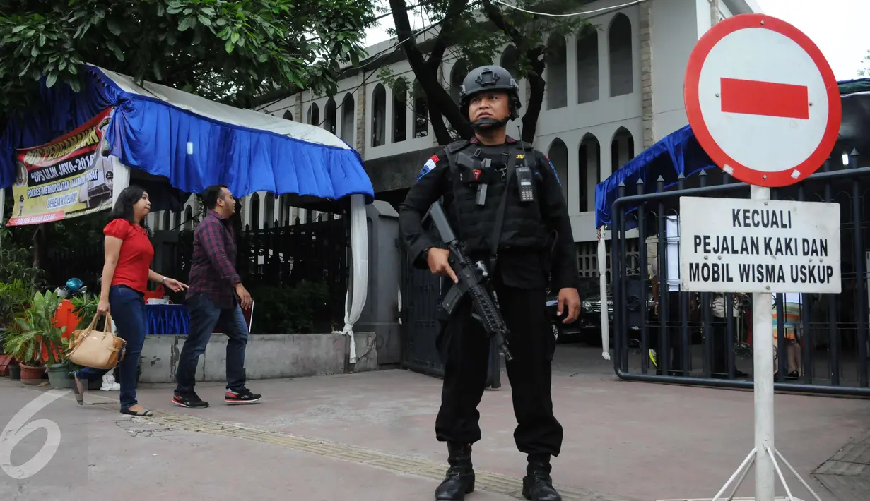 Petugas kepolisian berjaga di depan Gereja Katedral, Jakarta, Sabtu (24/12). Penjagaan dilakukan untuk menjaga kondusifitas agar acara Malam Misa Natal bisa berjalan lancar. (Liputan6.com/Helmi Afandi) 