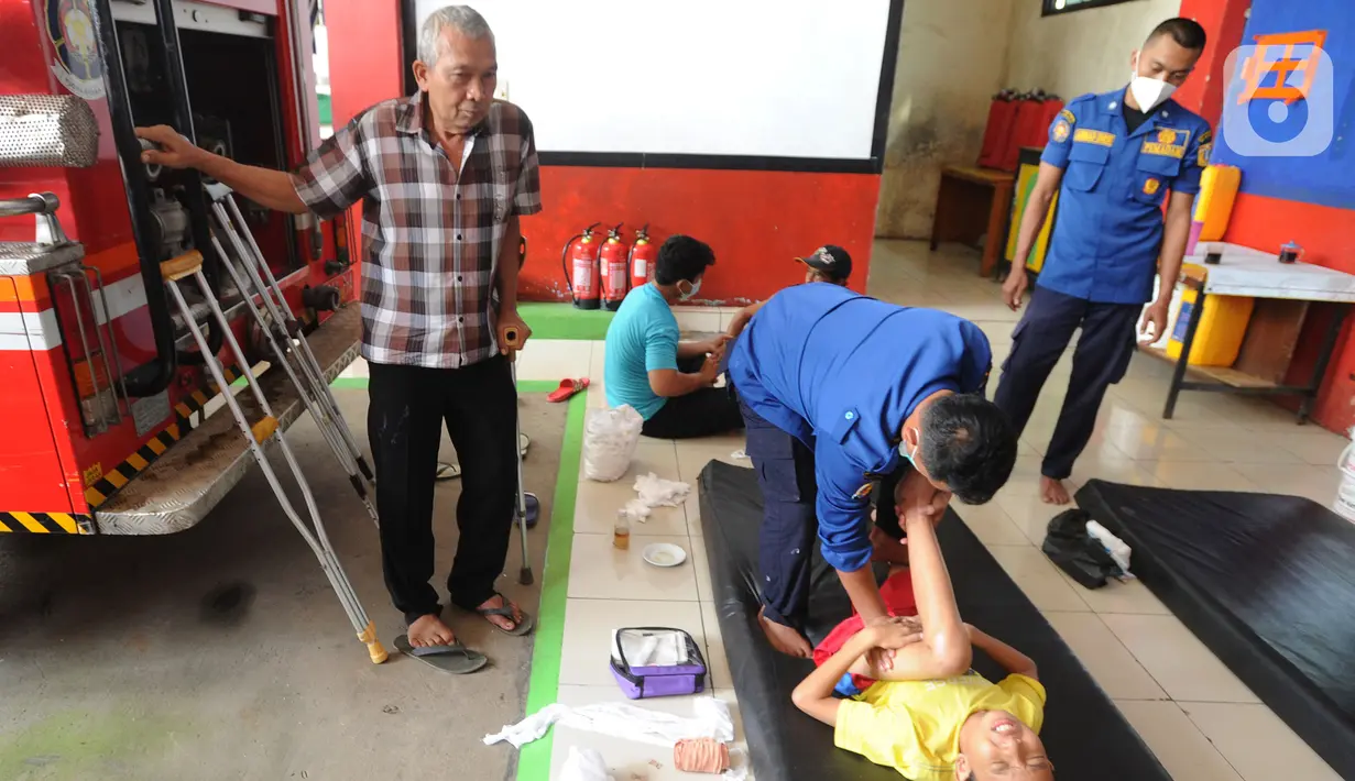 Petugas Damkar mengobati seorang anak yang mengalami patah tulang di Pos Damkar Ciganjur, Jagakarsa, Jakarta Selatan, Rabu (2/12/2020). Setiap Minggunya beragam pasien yang rata-rata mengalami patah tulang dari kawasan Jakarta, Tangerang, dan Depok datang berobat. (merdeka.com/Arie Basuki)