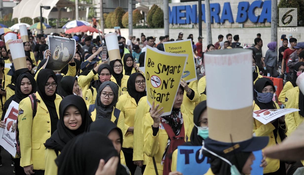 Mahasiswa Universitas Indonesia (UI) membawa spanduk saat menggelar kampanye Bahaya Merokok di car free day (CFD), Jakarta, Minggu (6/5). Dalam aksi tersebut para mahasiswa juga menyerukan tentang bahaya merokok. (Merdeka.com/Iqbal Nugroho)