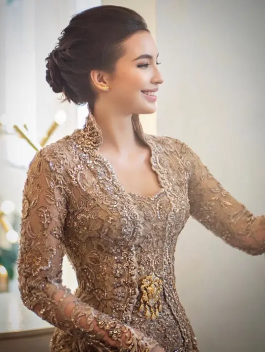 Manohara tampil memesona dengan kebaya brokat berwarna gold rancangan Anne Avantie. Kebaya ini memiliki detail kerah tinggi yang memberikan kesan ningrat. Untuk melengkapi tampilan, ia mengenakan bros emas yang semakin mempertegas keanggunannya. [@manodelia].