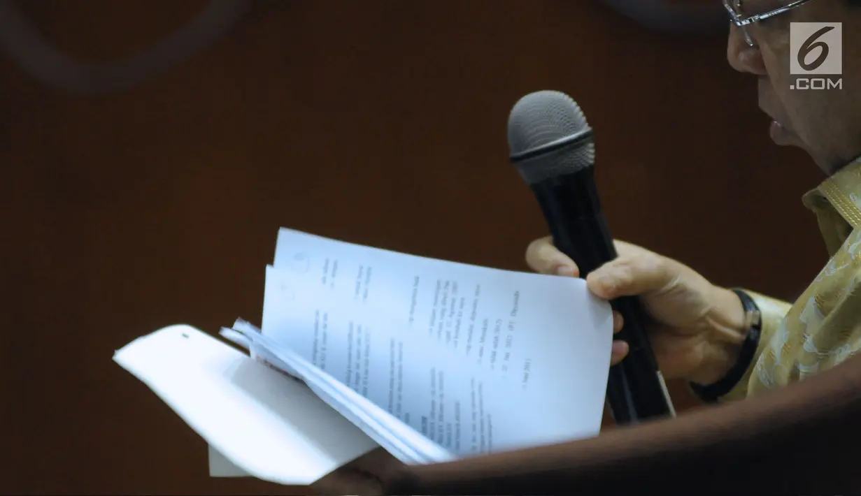 Terdakwa dugaan korupsi proyek e-KTP, Setya Novanto membuka buka catatan saat menjadi saksi pada sidang lanjutan di Pengadilan Tipikor, Jakarta, Kamis (22/3). Sidang mendengar kesaksian terdakwa. (Liputan6.com/Helmi Fithriansyah)