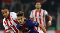 Pemain Barcelona, Denis Suarez berebut bola dengan pemain Olympiakos, Vadis Odjidja-Ofoe pada laga babak penyisihan Grup D Liga Champions di Georgios Karaiskáki, Rabu (1/11). Barcelona hanya mampu bermain imbang dengan skor 0-0. (AP/Thanassis Stavrakis)
