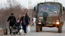 Truk militer Turki melintas saat para migran berjalan menuju perbatasan Yunani di Gerbang Pazarkule, Edirne, Turki, Selasa (3/3/2020). (AP Photo/Darko Bandic)