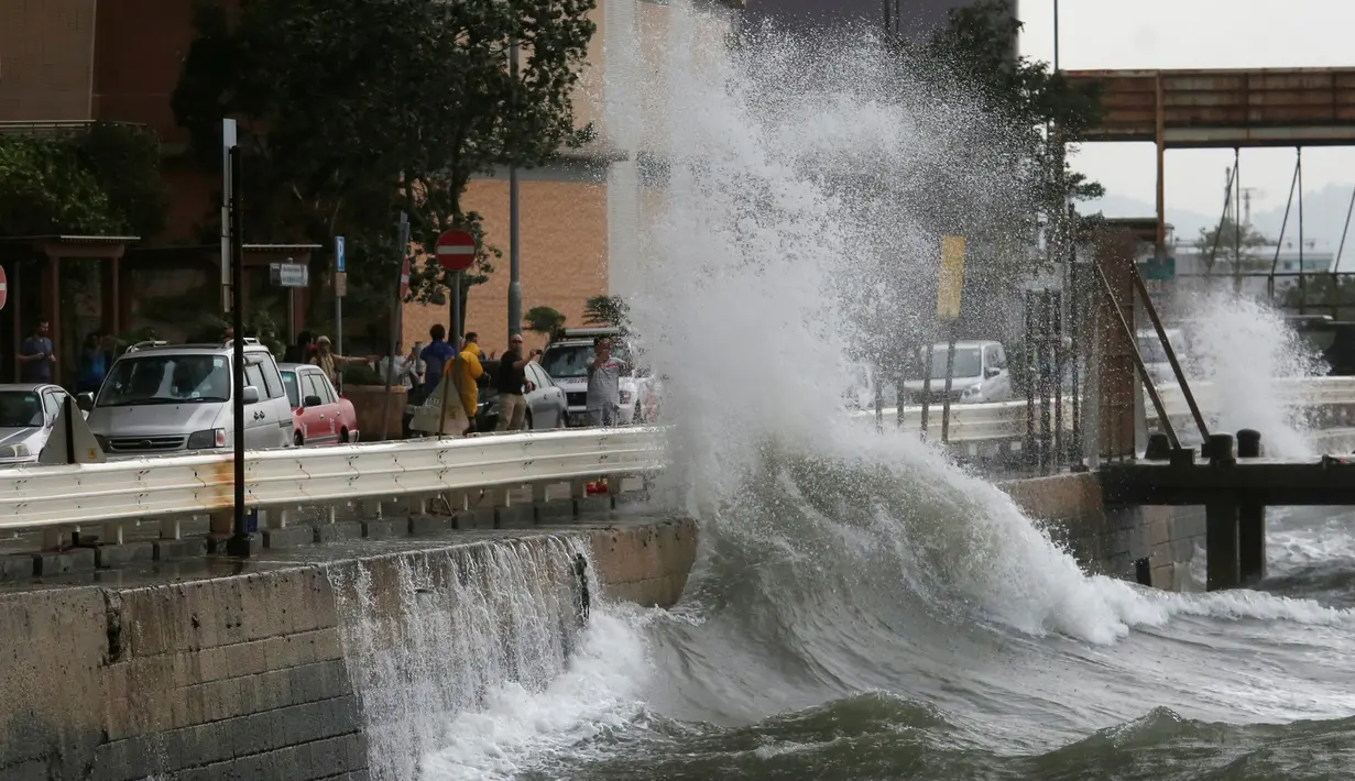 Sejumlah warga menyaksikan ombak besar di pesisir Hong Kong, Tiongkok, Jumat (21/10). ). Sebelum tiba di Hongkong, topan Haima terlebih dulu menerjang Filipina. (REUTERS/Bobby Yip) 