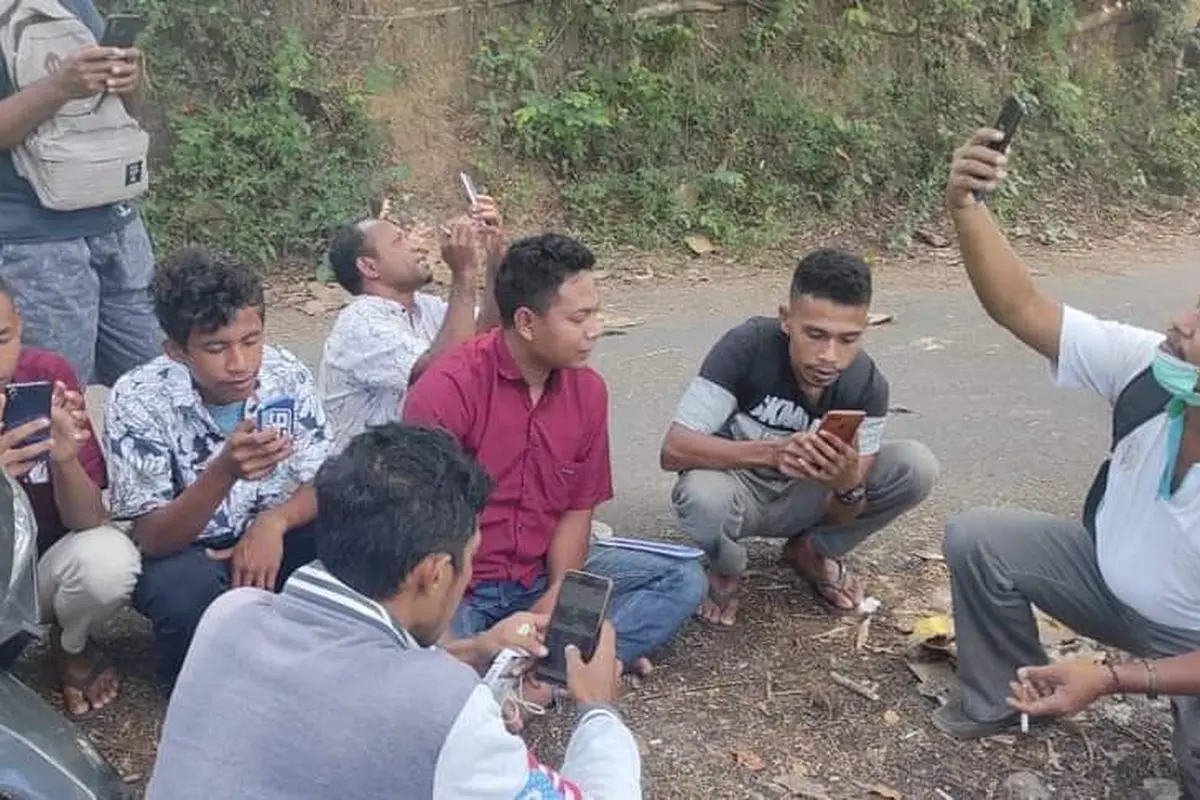 Warga, perangkat desa dan pendamping desa sedang mencari sinyal di daerah yang bisa masuk jaringan internet. (Liputan6.com/ Dionisius Wilibardus)
