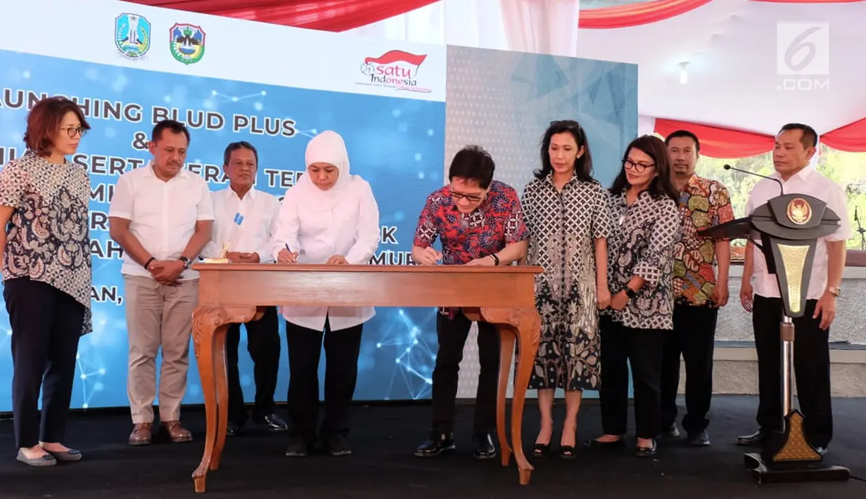 Gubernur Jawa Timur Khofifah Indar Parawansa dan Direktur Astra Paulus Bambang Wijanarko menandatangani piagam serah terima gedung sekolah baru SMKN 2 Donorojo, Pacitan yang merupakan Yayasan Pendidikan Astra - Michael D. Ruslim (YPAMDR), Minggu (7/7/2019). (Liputan6.com/HO/Ilham)
