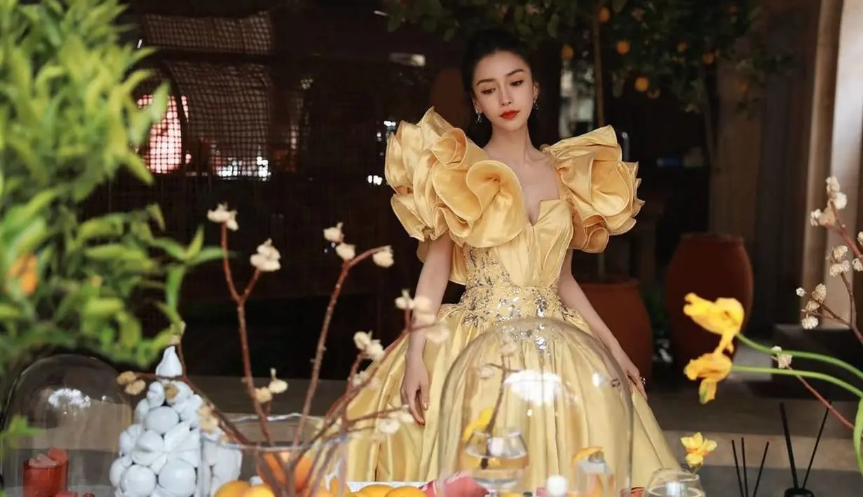 Tampil seperti Belle di film Beauty and the Beast, Angelababy mengenakan ball gown dari Elie Saab. Potongan puff sleeve memberikan volume yang penuh di bagian bahu.