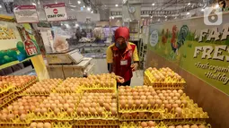 Karyawan memilih telur yang dibatasi dengan plastik di supermarket AEON Mall BSD City, Tangerang, Rabu (3/6/2020). Pembatasan tersebut dilakukan untuk memberikan jarak sosial dalam interaksi antara karyawan dan konsumen selama pandemi Covid-19. (Liputan6.com/Fery Pradolo)