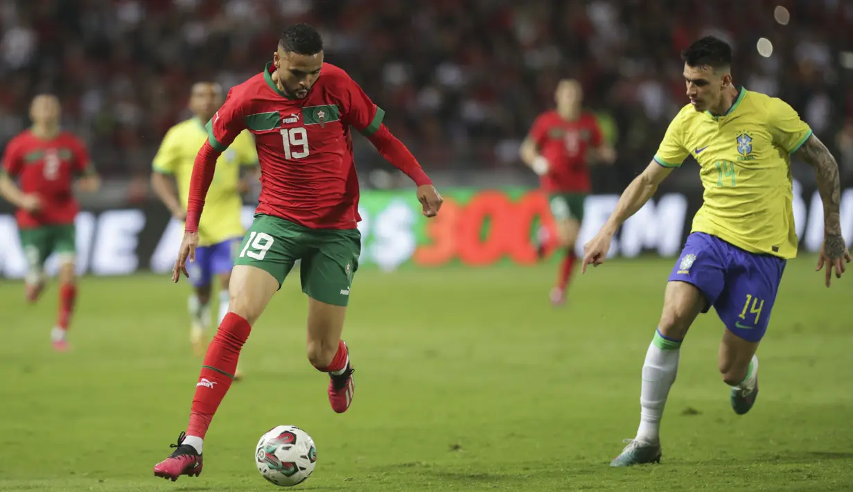 Pemain Maroko, Youssef En-Nesyr, berusaha melewati pemain Brasil, Ibanez, pada laga uji coba FIFA Matchday di Grand Stade de Tanger, Tangier, Minggu (26/3/2023). (AP Photo/Mosa'ab Elshamy)