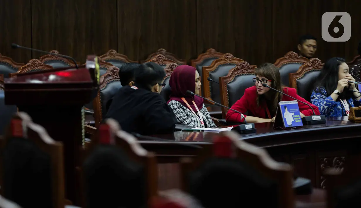 Politikus PSI Tsamara Amany (kedua kanan) berbincang dengan kuasa hukumnya saat mengikuti sidang putusan gugatan aturan umur kepala daerah di UU Pilkada di Mahkamah Konstitusi, Jakarta, Rabu (11/12/2019). MK menolak permohonan batas minimal usia calon kepala daerah. (Liputan6.com/Faizal Fanani)