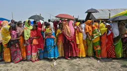 Para pemilih berdiri dalam antrean untuk memberikan suara mereka saat pemungutan suara tahap kedua untuk pemilihan umum India di desa Gashbari di distrik Darrang, negara bagian Assam pada tanggal 26 April 2024. (Biju BORO/AFP)
