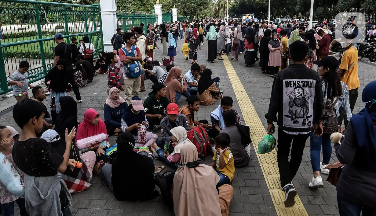 Warga memanfaatkan libur tahun baru 2023 dengan mengunjungi kawasan Monumen Masional (Monas), Jakarta, Minggu (1/1/2023). Monas menjadi salah satu destinasi wisata favorit warga baik dari Jakarta, maupun luar ibu kota, untuk menikmati liburan tahun baru. (Liputan6.com/Johan Tallo)