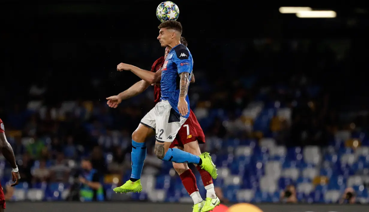 Pemain Napoli, Giovanni Di Lorenzo melompat saat berebut bola dengan gelandang Liverpool, James Milner pada matchday pertama Grup E Liga Champions di Stadion San Paolo, Selasa (17/9/2019). Napoli menundukkan Liverpool 2-0. (AP/Gregorio Borgia)