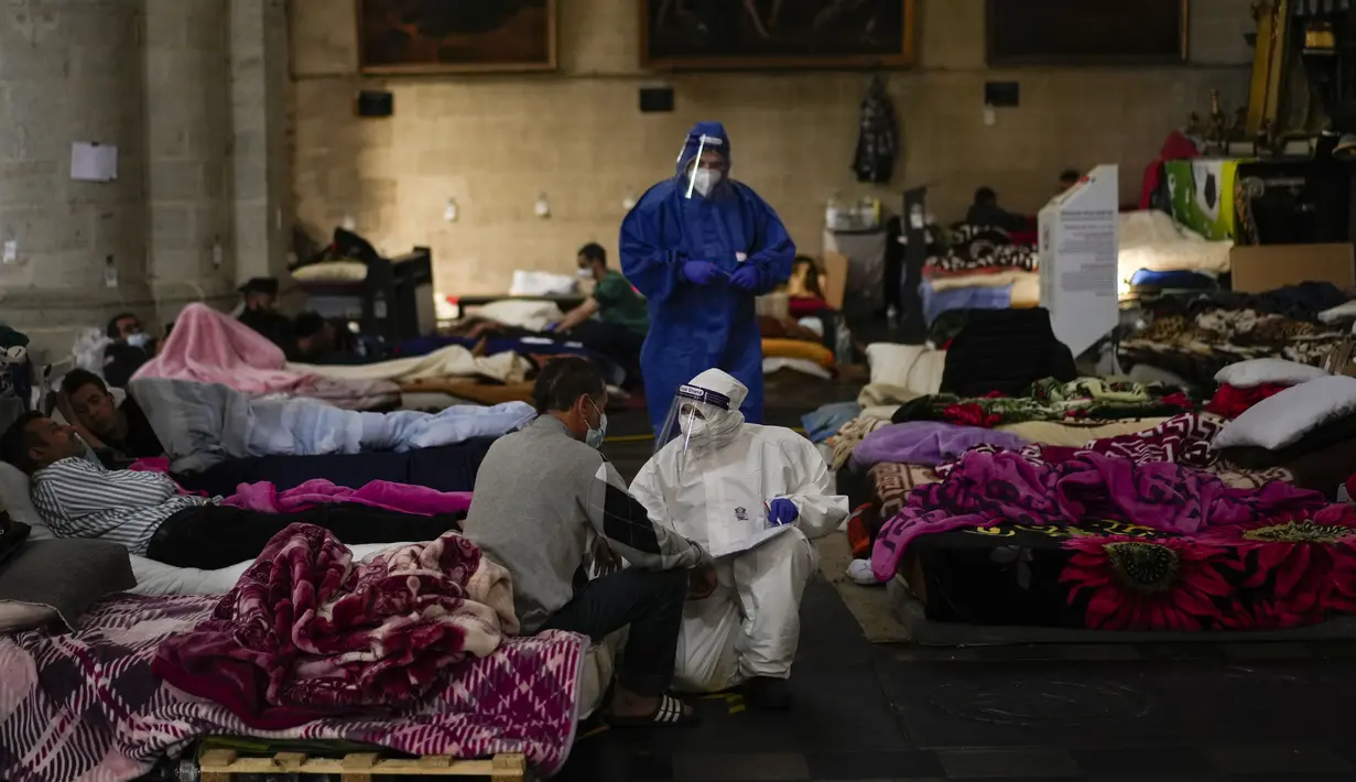 Petugas kesehatan Palang Merah mengurus aksi mogok makan saat menempati gereja Saint-Jean-Baptiste-au-Beguinage di Brussel, Senin (7/6/2021). Puluhan migran tanpa surat resmi tersebut mogok makan untuk menarik perhatian otoritas Brussel atas penderitaan mereka. (AP Photo/Francisco Seco)