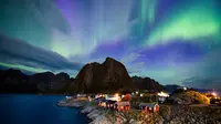 Cahaya utara (aurora borealis) menghiasi langit di atas Reinfjorden di Reine, di Kepulauan Lofoten, Lingkaran Arktik (8/9). Biasanya cahaya Aurora  bisa terlihat di sekitar daerah kutub utara dan selatan. (AFP Photo/Jonathan Nackstrand)