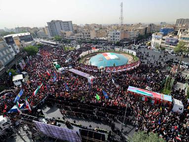 Ribuan orang memadati Lapangan Enqelab saat truk-truk yang membawa peti jenazah komandan militer dan ilmuwan Iran yang tewas selama serangan Israel melintas selama prosesi pemakaman di ibu kota Teheran pada 28 Juni 2025. (ATTA KENARE/AFP)