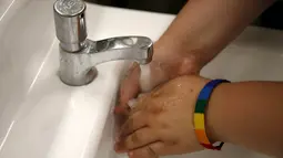 Seorang siswa mencuci tangan di toilet netral gender pertama di Santee High School, Los Angeles, California, AS, Senin (18/4). Toilet disediakan sebagai langkah mendukung dan menampung siswa transgender. (REUTERS/Lucy Nicholson)
