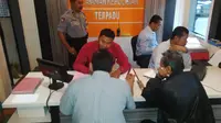 Ayah AT memakai jaket warna hitam ditemani kuasa hukum Iwan Pangka melapor ke polisi (Liputan6.com/ Reza Kuncoro)