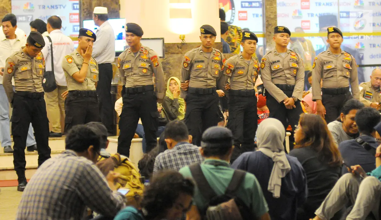 Aparat Kepolisian berjaga di depan pintu masuk lobby debat cawapres 2019 di Hotel Sultan, Jakarta, Minggu (17/3). Polisi menerapkan empat ring pengamanan yang dijaga oleh Paspampres, TNI Polri, dan Polda Metro Jaya. (Liputan6.com/Angga Yuniar)