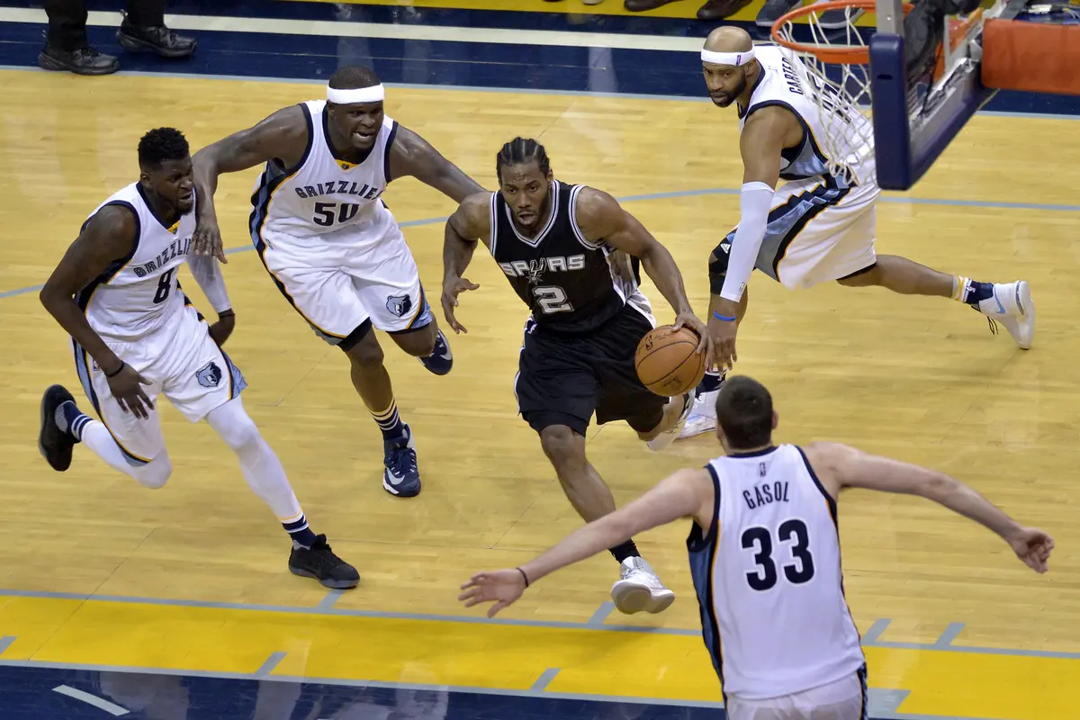 Forward San Antonio Spurs Kawhi Leonard (2) melewati kepungan pemain Memphis Grizzlies pada pertandingan di FedExForum, Jumat (28/4/2017) pagi WIB. Spurs menang 103-96. 