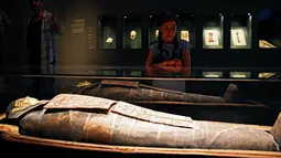 Seorang gadis mengamati mumi berusia 2.200 tahun yang dipajang di Museum Israel, Yerusalem, Rabu (27/7). Mumi Mesir berjenis kelamin pria berusia 30-40 tahun itu bernama "Iret-hor-r-u", yang berarti "Pelindung Mata Horus". (REUTERS/Ronen Zvulun)