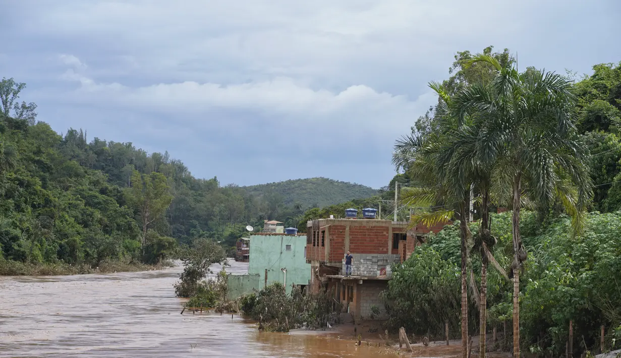 Banjir menutupi jalan perumahan di Raposos, negara bagian Minas Gerais, Brasil, Selasa (11/1/2022). Tanah longsor akibat hujan deras telah menewaskan sedikitnya 12 orang dan pihak berwenang sedang memantau bendungan yang bisa jebol. (AP Photo/Eugenio Savio)