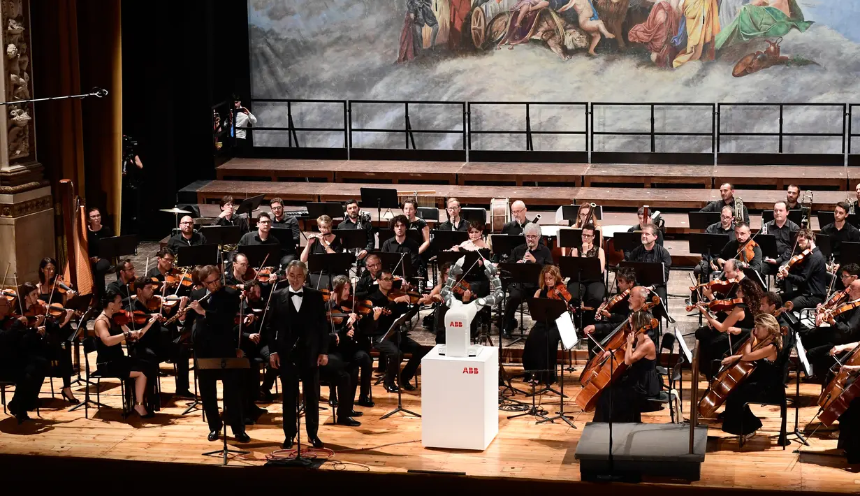 Suasana konser Lucca Philharmonic Orchestra yang dipimpin robot Humanaid YuMi di The Teatro Verdi di Pisa, Italia (12/9). (AFP Photo/Miguel Medina)