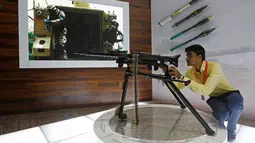 Seorang pengunjung mencoba senjata alat tempur saat Pameran Pertahanan Internasional dan Seminar "IDEAS 2016" di Karachi, Pakistan (23/11). Pihak penyelenggara menyatakan, lebih dari dua ribu berbagai macam senjata di pamerkan. (Reuters/Akhtar Soomro)