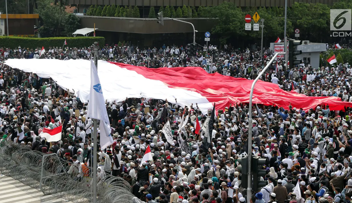 Peserta aksi massa Gerakan Nasional Kedaulatan Rakyat mengibarkan bendera Merah Putih raksasa saat melakukan unjuk rasa di perempatan dekat Gedung Bawaslu, Jakarta, Rabu (22/5/2019). Dalam aksinya, mereka meminta Bawaslu memeriksa kembali hasil Pemilu 2019. (Liputan6.com/Helmi Fithriansyah)
