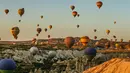 Balon udara membawa wisatawan naik ke langit saat matahari terbit di Kapadokia, Turki, Selasa (7/8). Kapadokia memiliki sejumlah keajaiban alam, khususnya Cerobong Peri (Fairy Chimney). (AP Photo/Emrah Gurel)