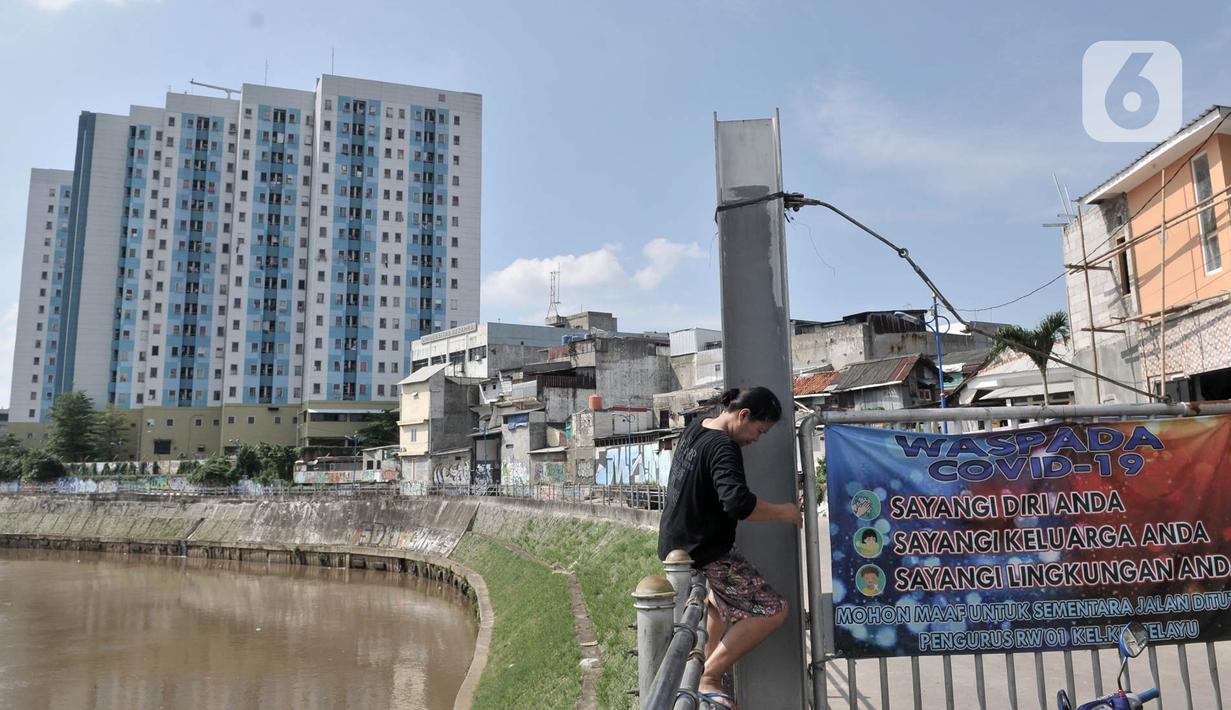 Warga memanjat pagar dekat Rusunawa Jatinegara Barat, Jakarta, Minggu (3/5/2020). Pemprov DKI Jakarta berencana membebaskan uang retribusi atau tarif rusunawa karena banyaknya penghuni yang tidak mampu membayar sewa akibat kesulitan ekonomi di tengah pandemi COVID-19. (merdeka.com/Iqbal S. Nugroho)