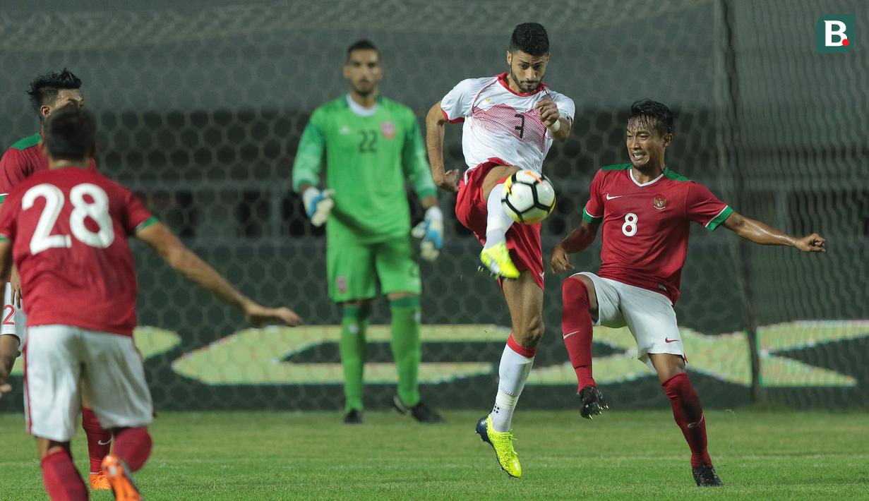 Duel pemain Timnas Indonesia U-23, Hargianto (kanan) dan pemain Bahrain pada laga PSSI Anniversary Cup 2018 di Stadion Pakansari, Bogor, (26/4/2018). Bahrain unggul sementara 1-0. (Bola.com/Nick Hanoatubun)