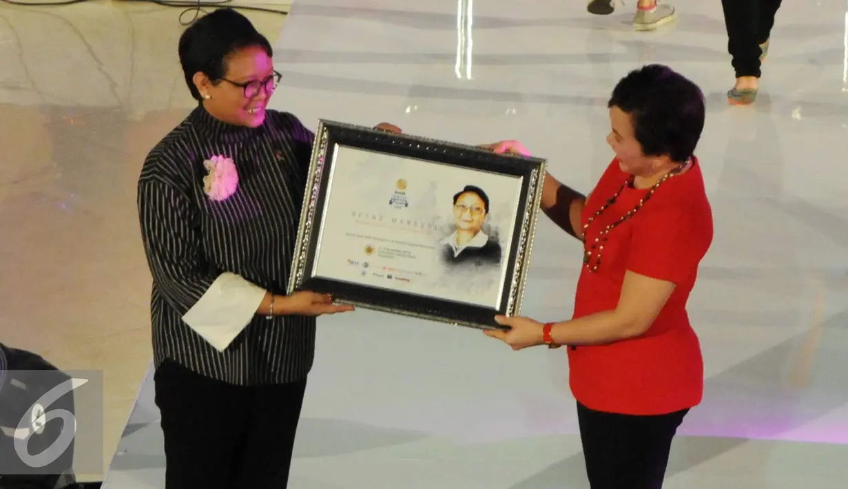 Direktur program SCM Harsiwi Acmad memberikan cendera mata kepada Menlu Retno Marsudi saat kegiatan Emtek Goes to Campus (EGTC) 2016 di Universitas Gadja Mada, Yogyakarta, Rabu (02/11). (Liputan6.com/Helmi Affandi)