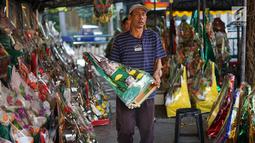 Pedagang membawa parsel yang dijual di kawasan Cikini, Jakarta, Selasa (28/5/2019). Penjualan parsel di kawasan ini menurun disebabkan turunnya permintaan, salah satunya akibat larangan menerima bingkisan bagi pejabat dan PNS di Indonesia oleh KPK. (Liputan6.com/Immanuel Antonius)