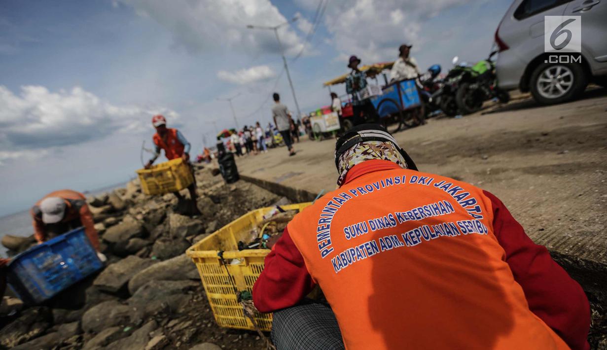Petugas kebersihan membersihkan sampah laut di Pelabuhan Kali Adem, Jakarta, Senin (1/1). Banyaknya sampah plastik dibandingkan ikan yang gagal dikelola dengan baik membuat limbah yang mengakibatkan laut tercemar.  (Liputan6.com/Faizal Fanani)